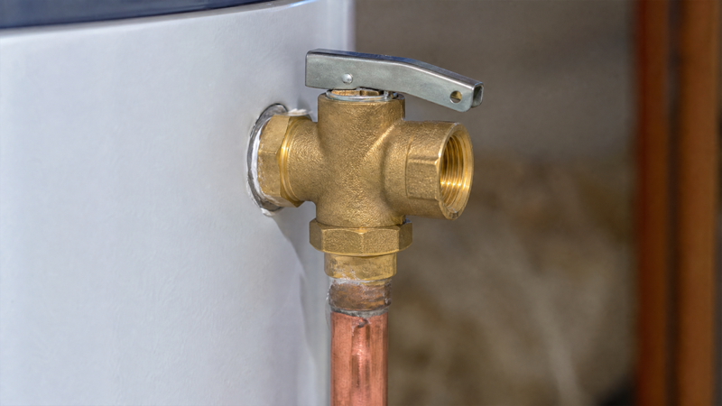 Macro view of brass water heater temperature and pressure relief valve assembly and copper discharge pipe